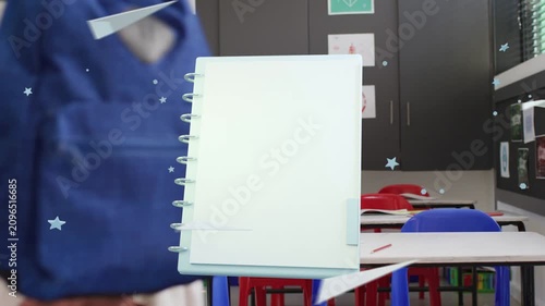 Students walking behind animated spiral notebook appearing, floating in classroom with backpacks