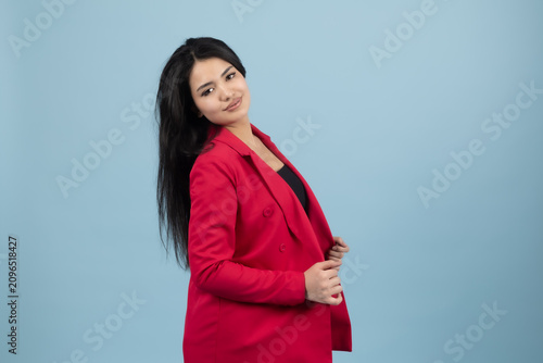 Fotografie Elegant young female model posing sideways in corporate suit