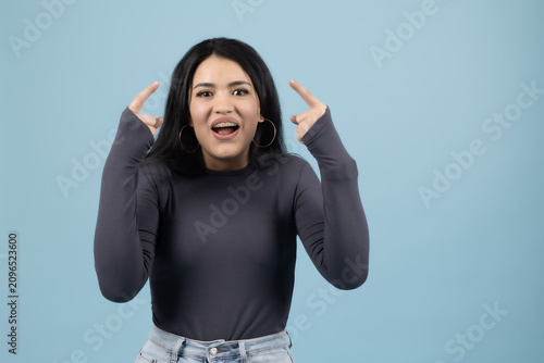 Canvastavla Surprised young woman holding hands up with open mouth expression