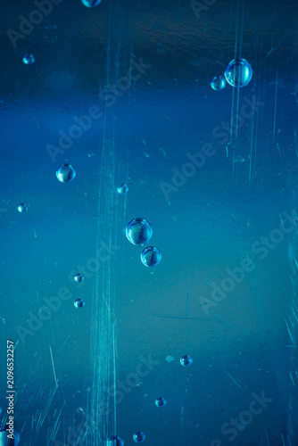 Tableau sur toile Close-up of air bubbles suspended in a deep blue liquid background
