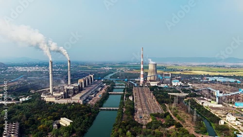 A thermal power station beside a canal with twin smoking stacks in Vijayawada, India in 2026
