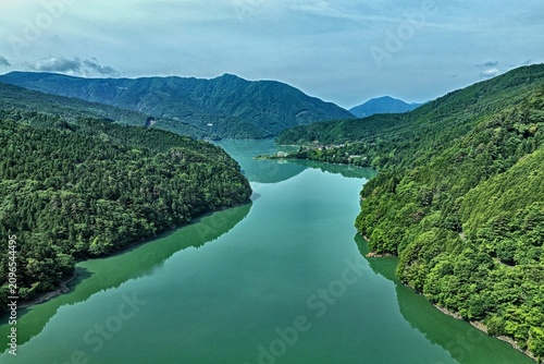 Photography Aerial drone photo of Ikawa Lake surrounded by green mountains in Shizuoka, Japa