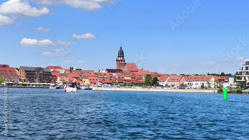 Scenic view from the water of a European town with red roofs and prominent church steeples on a sunny day