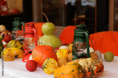 Canvas Print Colorful autumn bounty on a rustic table with lanterns and gourds in warm evenin
