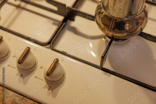 Принти на полотні Preparing a meal on a vintage gas stove with gleaming knobs and a polished coffe