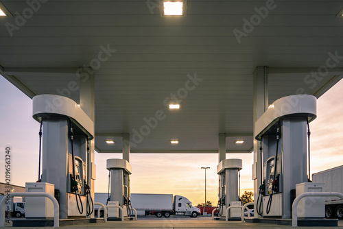 Foto Trucks refueling at a modern gas station during a beautiful sunset