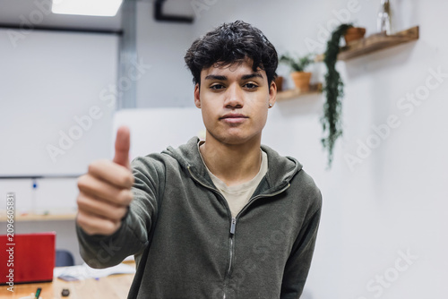 portrait of young latin man student with point finger in Latin America