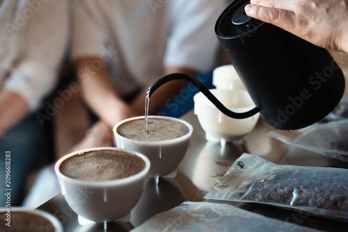 Obraz na płótnie Barista pouring hot water into coffee cupping bowls with gooseneck kettle