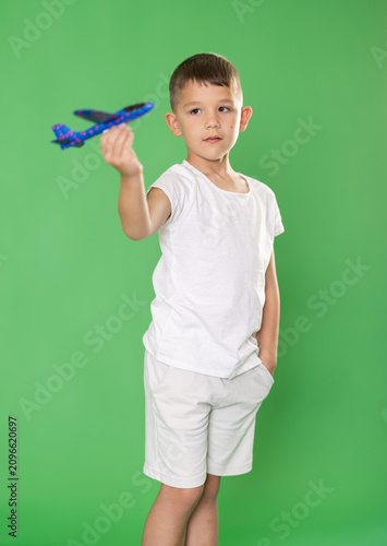 Foto Boy plays with airplane, imagines flying to distant countries, and sends toy flying