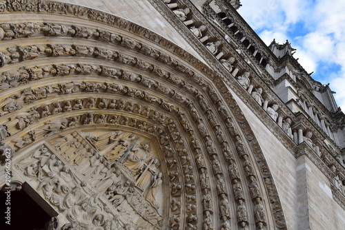 Fotografía Low angle view of the ornate Gothic portal and sculpted facade of Notre-Dame Cat