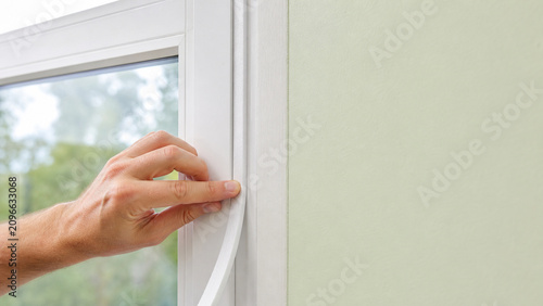 Hand Installing Window Weatherstripping Strip for Draft Prevention