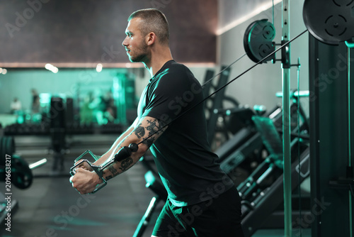 Εκτύπωση καμβά Strong man training on cable crossover machine in gym