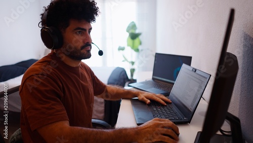 Foto Man working from home with a headset and laptop, remote employee