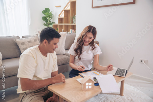 Couple lover make home financial plan. Young asian lover planning retire plan at home bedroom look at investment graph chart. Family finance investment happy together.