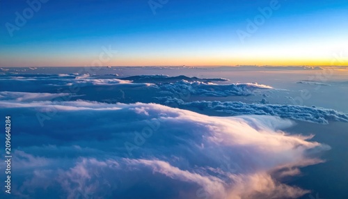 Aerial view of fluffy clouds at sunset golden hour.