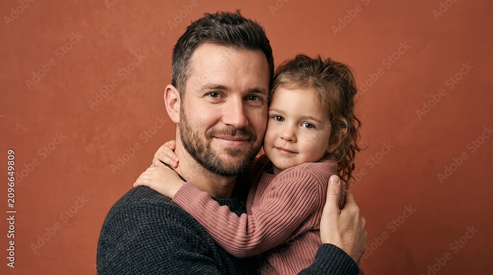 Fototapeta premium Father holding his young daughter in a warm embrace against a textured background