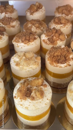 Sweet desserts and pastries are displayed behind a glass showcase in a bakery or cafe arranged for presentation and sale. Retail dessert display. Culinary and gastronomy.