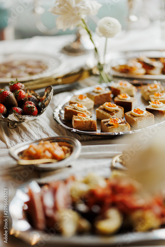 Elegant Catering Table with Canapes and Appetizers
Wedding Buffet with Finger Food and Fresh Strawberries
Banquet Table with Canapes Pastries and Floral Decor