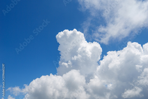 Photography White fluffy clouds float across the bright blue sky above the scenic mountains