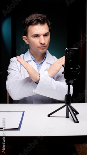 Принти на полотні Doctor engaging in a telemedicine video call, making a clear stop, refusal, or f