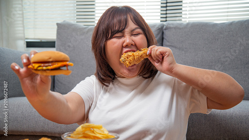Overweight Asian woman enjoying fast food at home