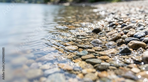 Clear water gently washing over smooth river stones on sunny shoreline, for purity, natural balance, serenity, calming flow time in peaceful outdoor environment