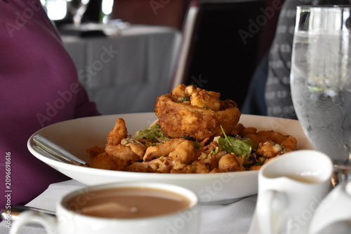 crispy calamari on a white plate at a restaurant table