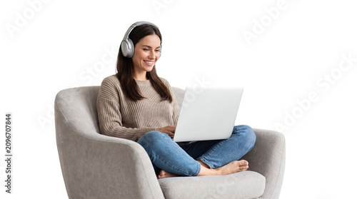 Woman with laptop and headphones. Freelancer sitting in chair using computer.