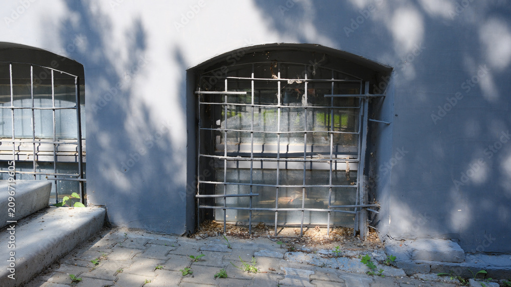 Αυτοκόλλητο A small window with a grate at ground level in the building, similar to a basement ventilation hole
