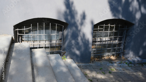 Cuadro en lienzo A small window with a grate at ground level in the building, similar to a basement ventilation hole
