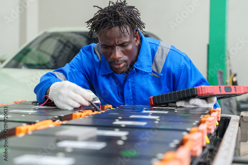 Принти на полотні Technician diagnosing electric vehicle batteries in a repair shop for optimal en