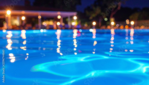 Illuminated Swimming Pool at Night with Reflections.