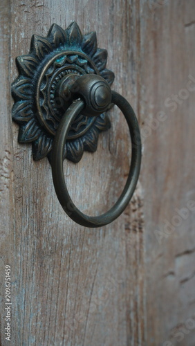 Obraz na plátně Side Angle View of Antique Brass Sunflower Door Knocker on Rustic Wood
