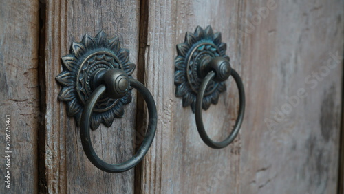 Fotografie Side Perspective View of Antique Brass Door Knockers on Old Wooden Door