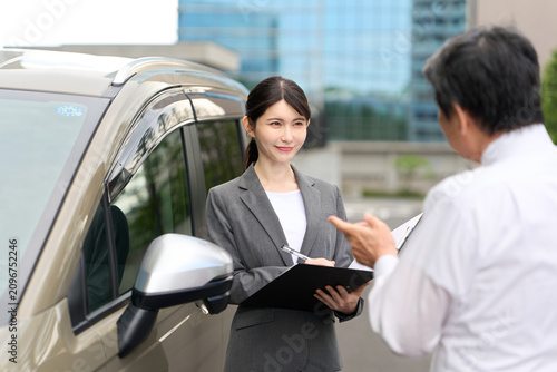 車の販売をするアジア人ビジネスウーマン