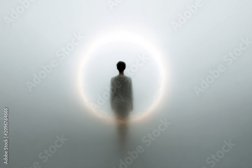 Minimal luminous mandala portrait of a solitary figure standing inside a glowing circular light for meditative background and spiritual design