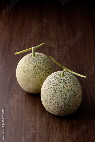 木目テーブルに置いた高品質な北海道産のメロン
High-quality Hokkaido melon on a wooden table,