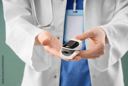 Doctor holding a pulse oxim...