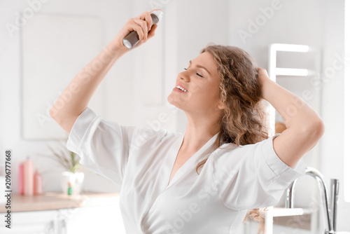Young woman applying dry sh...