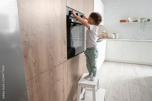 Little boy on step stool op...