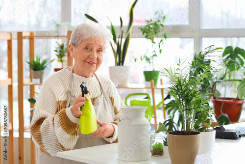 Senior florist with spray w...