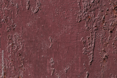 Violet textured background with rust and paint cracks. Reddish-brown base. Raised patches of paint. The aged surface of the steel sheet. Natural shadows