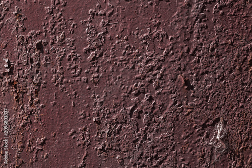 Violet textured background with rust and paint cracks. Reddish-brown base. Raised patches of paint. The aged surface of the steel sheet. Natural shadows
