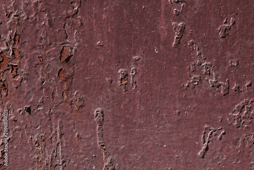 Violet textured background with rust and paint cracks. Reddish-brown base. Raised patches of paint. The aged surface of the steel sheet. Natural shadows
