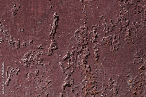 Violet textured background with rust and paint cracks. Reddish-brown base. Raised patches of paint. The aged surface of the steel sheet. Natural shadows