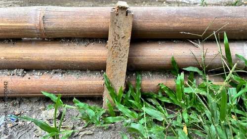 Close-Up of Wooden Poles Surrounded by Green Grass and Soil