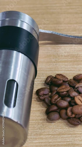 Manual Stainless Steel Coffee Grinder with Roasted Coffee Beans on Wooden Table