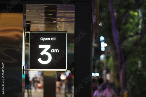 Foto Store hours display shows late night opening time