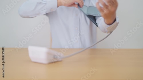 Man checking Blood pressure by Blood pressure monitor with Cuff. Systolic, SYS, Diastolic, DIA, Pulse, Hypertension, Hypotension, Heart rate, Cardiovascular Disease and May World hypertension day
