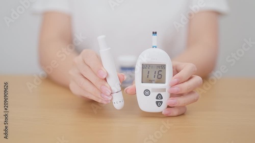 Hand checking Diabetes or Blood glucose self testing by digital blood glucose meter with lancet pen. high blood sugar level, World Diabetes Day, Glycemia, Hypoglycemia, Hyperglycemia and insulin